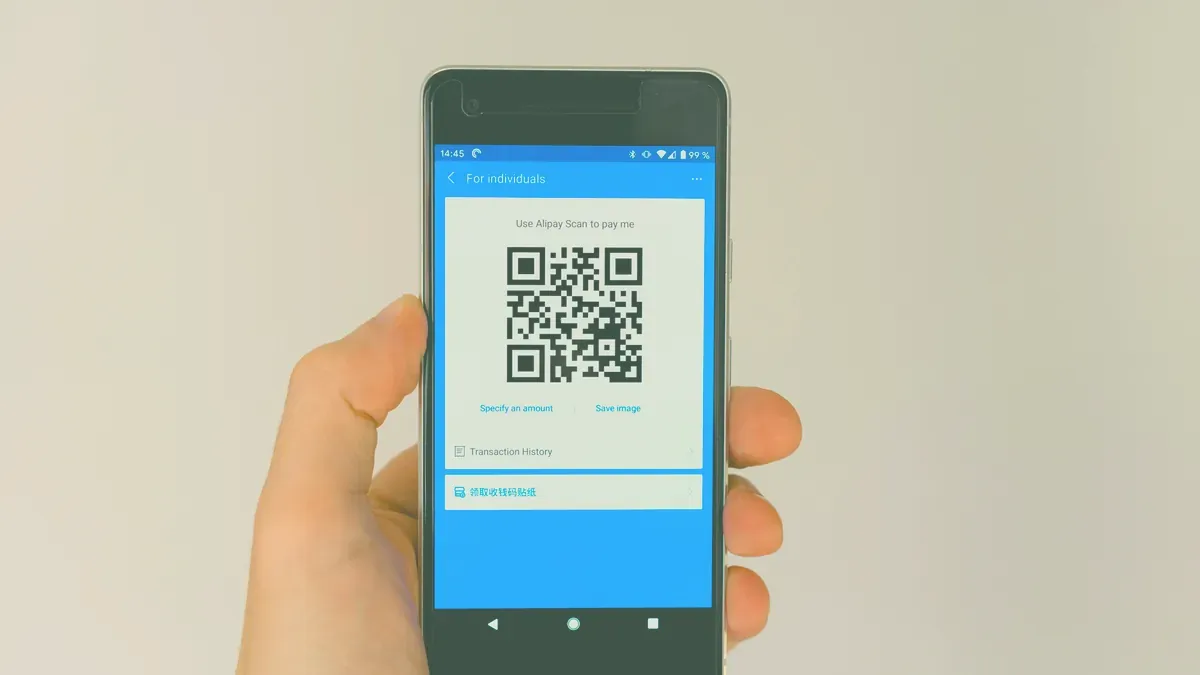 Mobiltelefon som visar en QR-kod, så som ett digitalt presentkort visas upp i kassan